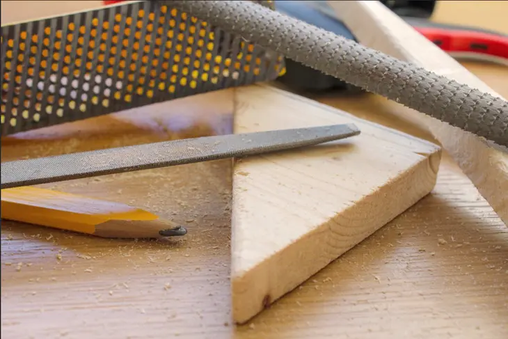 A woodworker applying a water-based, low-VOC finish to a wooden project, showcasing the use of non-toxic finishes in sustainable woodworking.