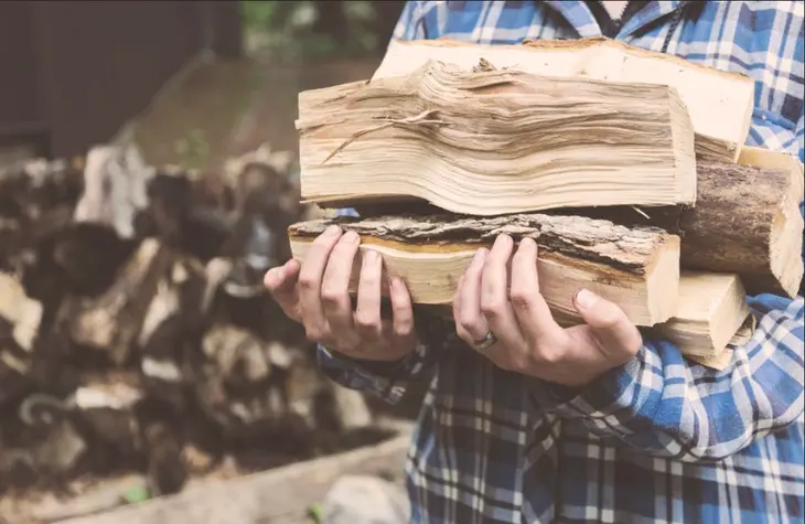 A person assembling a wooden outdoor bench on a patio, illustrating the process of creating custom furniture for outdoor spaces with DIY woodworking projects